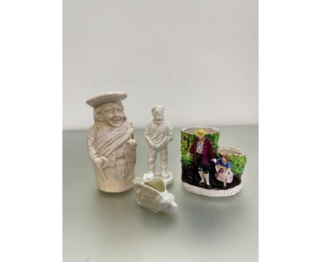A group of four ceramic figures, three early 20th centuary glaze in white ceramics, a fishform salt probably belleek, a toby 