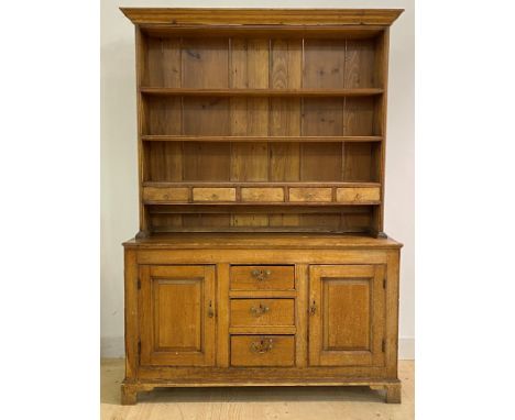 A pine dresser, early 19th century, the three height plate rack with five spice drawers, over base fitted with three centre d