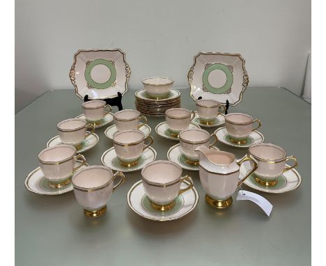 A Plant Tuscan china part tea service pattern no 780956 with a pale pink underglaze and green and gilt boarders, two cake pla