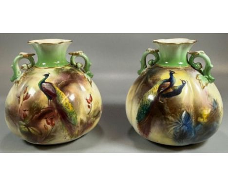 Two similar Royal Worcester Hadley's and Hadley Ware two handled vases, one hand-painted with a Peacock in a woodland setting