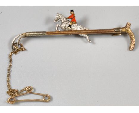 14ct gold novelty brooch in the form of a riding whip/crop with huntsman on horse. 7.3g approx. (B.P. 21% + VAT)