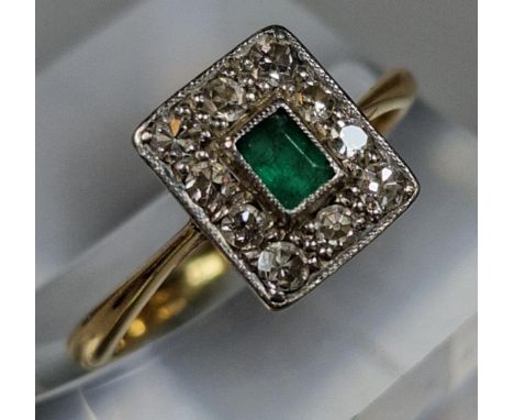18ct gold and platinum Art Deco design diamond and emerald ring, the central emerald stone surrounded by ten diamonds. 2.4g a