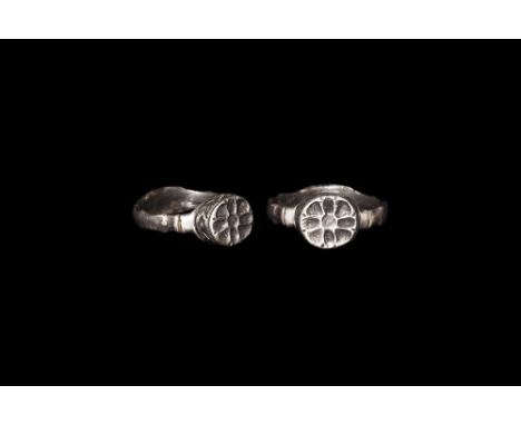 16th century AD. A D-section silver hoop with undulating borders, discoid bezel with Tudor rose, underside with clasped hands
