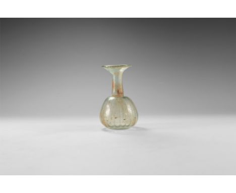 3rd-4th century AD. A piriform glass flask with dimple base, ribbed body, tubular neck with restriction to the lower end, fla