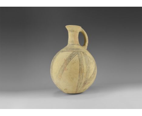 2nd millennium BC. A globular ceramic vessel with tall neck, everted rim, strap handle; bands of red and black painted hatchi
