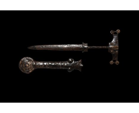 Early 1st millennium BC. An iron dagger with T-shaped pommel with two small roundels to the ends, central rib with hatched de