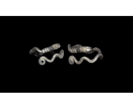1st century BC-1st century AD. A round-section silver rod formed into a ring of undulating profile, one coiled finial, the ot