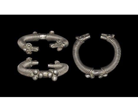 1st millennium BC. A substantial silver penannular bracelet, round in section with wire coils to the shank, two groups of thr
