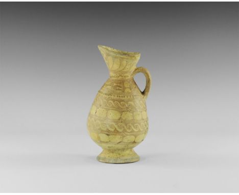8th-10th century AD. A ceramic ewer with flared base and piriform body, funicular neck with extended pouring lip, raised circ