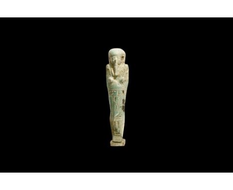Ptolemaic Period, 305-30 BC. A pale blue glazed composition shabti with tripartite wig, false beard, tools in the crossed han
