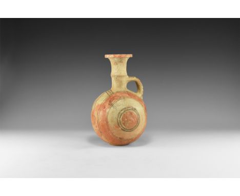 8th-7th century BC. An unglazed ceramic jug with low basal ring, globular body, trumpet-shaped neck with carination and chamf