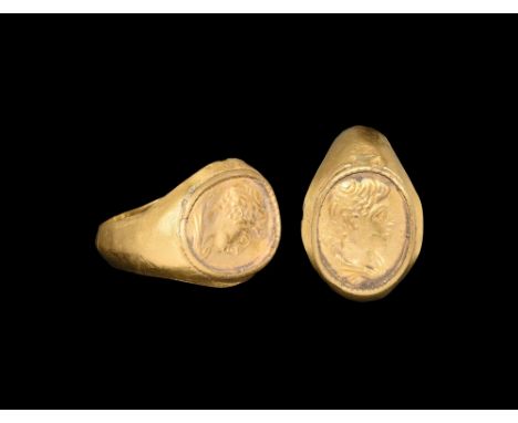 3rd century AD. A hollow-formed D-section gold hoop with raised rim to the bezel, repoussé portrait bust of a youthful male. 