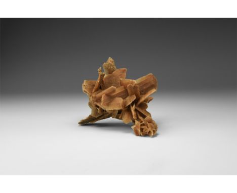 A selenite gypsum 'desert rose' composed of blades of selenite with gypsum sand inclusions, many forming 'hourglass' shapes i