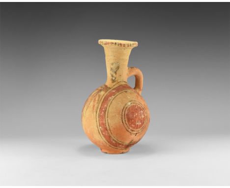 8th-7th century BC. An unglazed ceramic jug with basal ring, globular body, trumpet-shaped neck with chamfered rim, round-sec