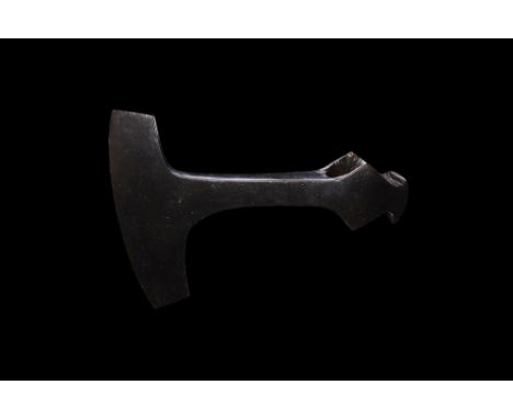 10th-12th century AD. An iron axehead with narrow T-shaped blade, curved edge, lozenge wings to the socket, hammer-head to th