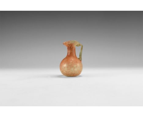 3rd-4th century AD. A bulbous glass flask with red and white pigmentation, tapering neck, folded trefoil flange rim, strap ha