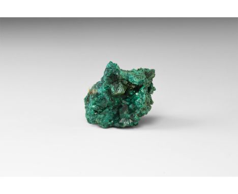 A cluster of richly coloured dioptase crystals on a hematite matrix, in white card tray. See Bonewitz, Dr. Ronald Louis, Rock