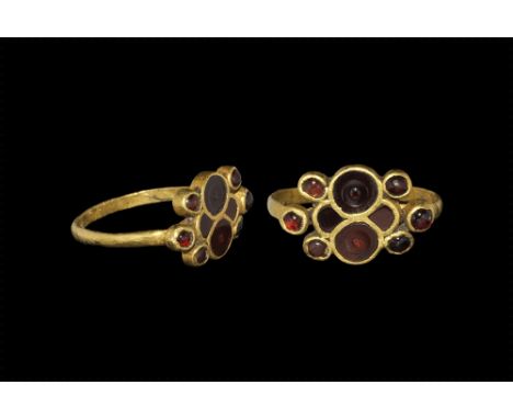 5th-6th century AD. A flat-section D-shaped hoop, plaque composed of two large discoid cells set with garnet cloisons, each w