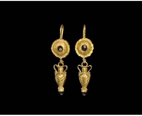 2nd-3rd century AD.A matched pair of gold earrings, each a hook with granule, domed plaque with crimped edge and inset garnet