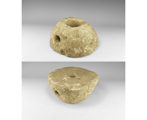 1st-3rd century AD. A plano-convex upper stone from a beehive rotary quern with filling hole to the centre and tapered hole t