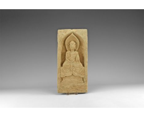 Northern Wei Dynasty, 386-534 AD. A carved stone architectural panel depicting a seated Buddha on a throne, the right hand ex