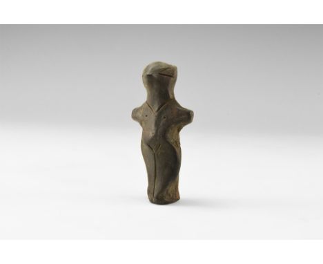 Neolithic, 6th-4th millennium BC. A ceramic figurine with pinched facial features, stub arms, incised hair and other details,