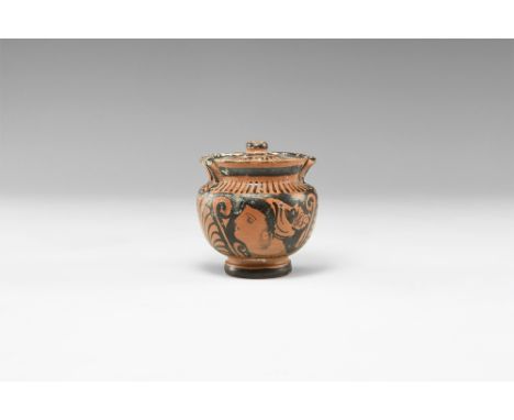 Apulian, 5th-3rd century BC. A ceramic blackware lidded pyxis with integrally moulded faux handles to the shoulder and neck; 