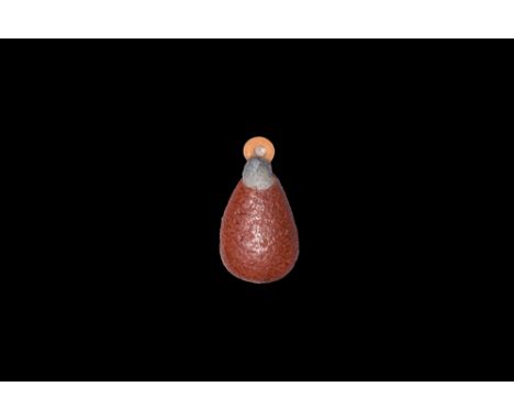 Amarna Period, 1353-1336 BC. A glazed composition amuletic pendant of a poppy petal with loop to one end and another to the r