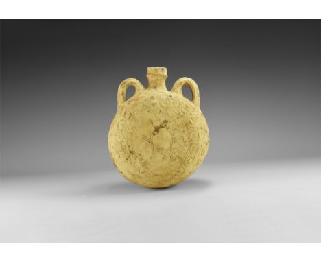 11th-6th century BC. A terracotta flask with drum-shaped body, trumpet -shaped neck with lateral loop handles; ring of rosett