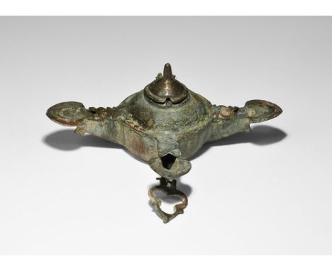 12th-13th century AD. A bronze oil lamp with central reservoir and three nozzles each with leaf-shaped flanged rim, hinged li