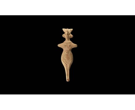 1180-700 BC. A ceramic idol figurine with lozengiform lower body rising to flat-section upper body, depicting a standing fema