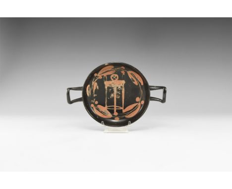 Apulian, 5th-3rd century BC. A ceramic blackware kylix with pedestal base and square handles, shallow bowl; reserved band of 
