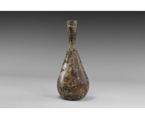 2nd-3rd century AD. A glass vessel with piriform body, dimple base, flared tubular neck, iridescent surface. Cf. Whitehouse, 