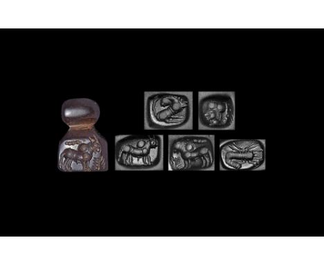 2nd millennium BC. A hammer-handled haematite stamp seal with pierced suspension bulb, five intaglio designs comprising a zeb