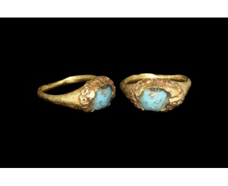 3rd century AD. A hollow-formed D-section gold hoop with cusped shoulders, scaphoid plaque with filigree collar, inset glass 