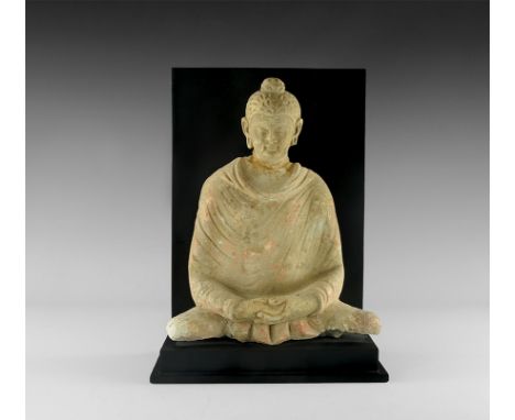 3rd-5th century AD. A statuette of Buddha seated cross-legged with hands folded in the lap; coral pink pigment remaining; mou