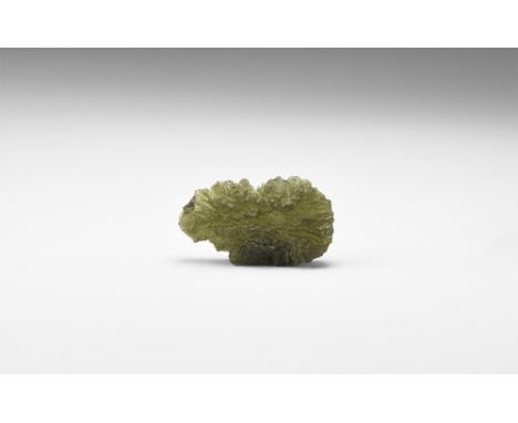 A piece of dark green, transparent moldavite showing good ablation figures; moldavite is melted material splashed out of the 