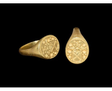 Late 16th-early 17th century AD. A gold ring with tapering shank, widening at the shoulders to a round flat bezel engraved wi