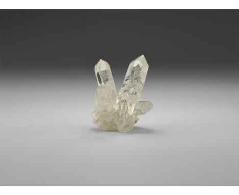 A beautifully formed cluster of three major and several minor bright and highly transparent quartz crystals, in white card tr