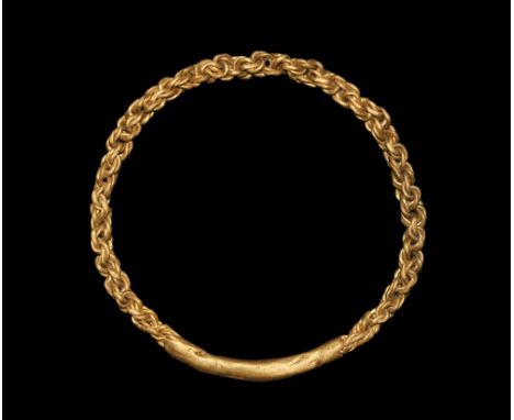 9th-11th century AD. A round-section bracelet of double-strand braided gold wires with hammer-welded block to the underside. 