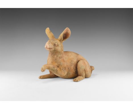 Tang Dynasty, 618-906 AD, or later. A terracotta figurine of a rabbit modelled in the round with one forepaw raised, ears pri