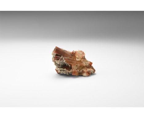 A group of orange-brown, prismatic topaz crystals on a crystalline rhyolite matrix, from the famous Mexican locality, in whit