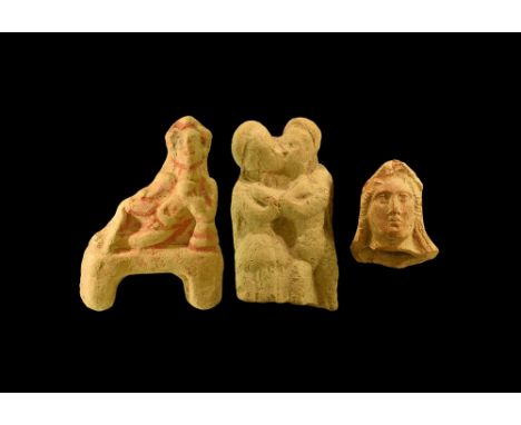 4th-2nd century BC. A mixed ceramic group comprising: a female head fragment with covered hair; a banqueter holding a cup, ac