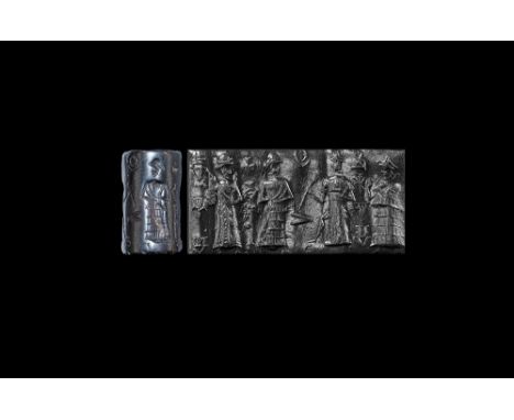 19th-15th century BC. A haematite cylinder seal with four standing figures and cuneiform text; accompanied by an old scholarl