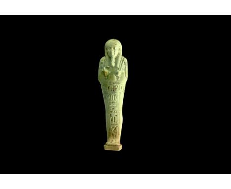 Late Period, 30th Dynasty, 380-343 BC. A pale blue glazed composition shabti with tripartite wig, false beard, implements in 