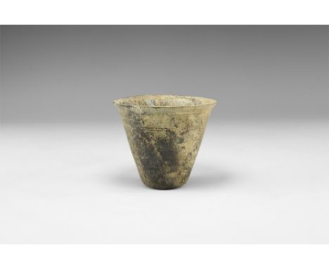 3rd-4th century AD. A blue glass conical cup with flared rim and incised concentric bands. Cf. Whitehouse, D. Roman Glass in 