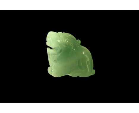 20th century AD. A carved jade pixiu modelled in the round with gaping mouth, pierced for suspension at the chin and neck.  1
