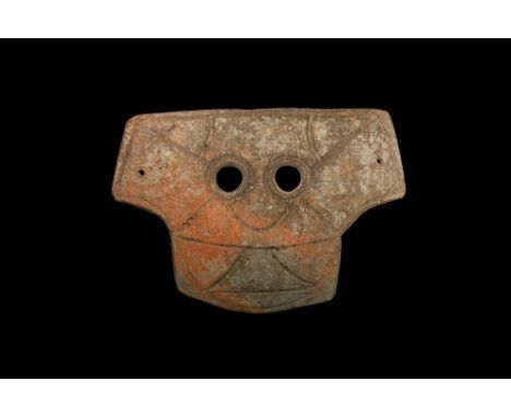 4th-3rd century BC. A large T-shaped slightly curved ceramic mask with two eye-holes and incised stylised facial details; pie