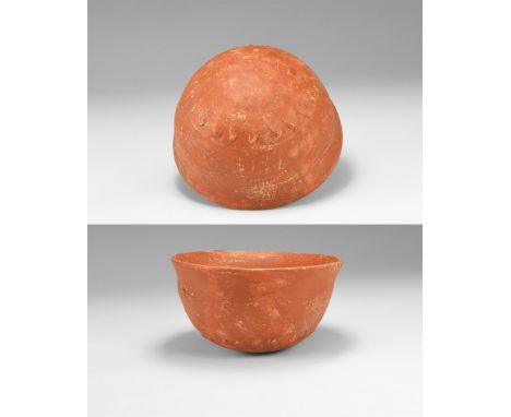 1st -3rd century AD. A ceramic cup in terra sigillata with rounded bottom and flared rim, overlapping petal motifs to the und