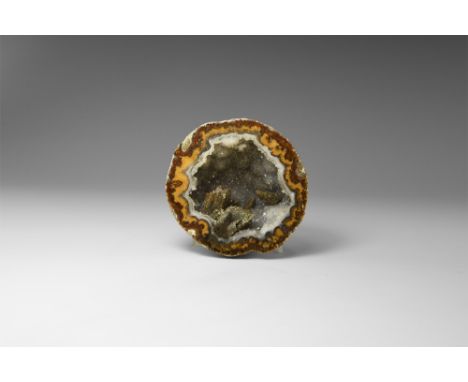 A sawn and polished half of a Mexican 'coconut' geode comprised of several brown and yellow-brown calcite layers, lined with 